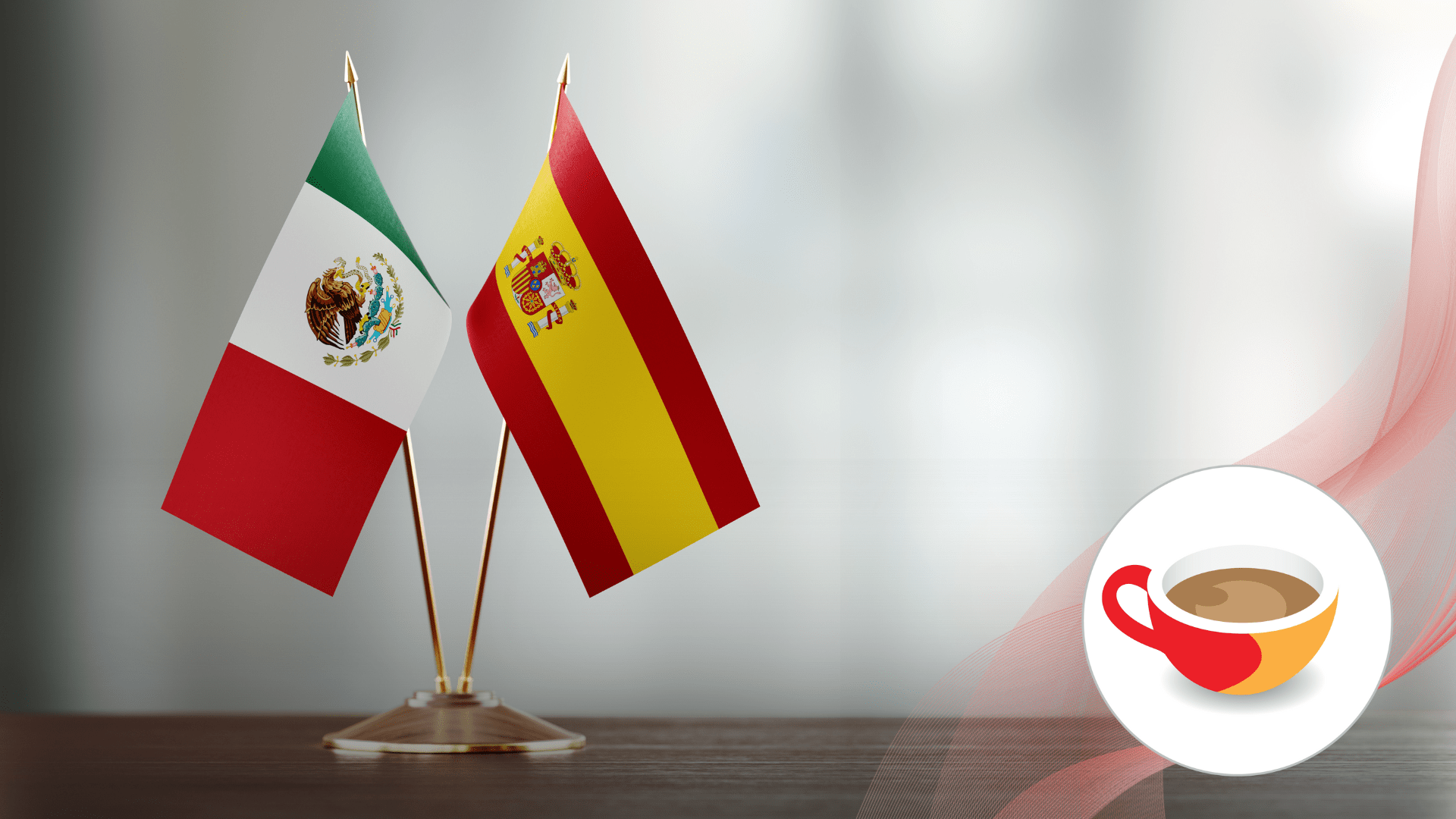 Two small table flags, one of Mexico and one of Spain, crossed over a dark base against a light background