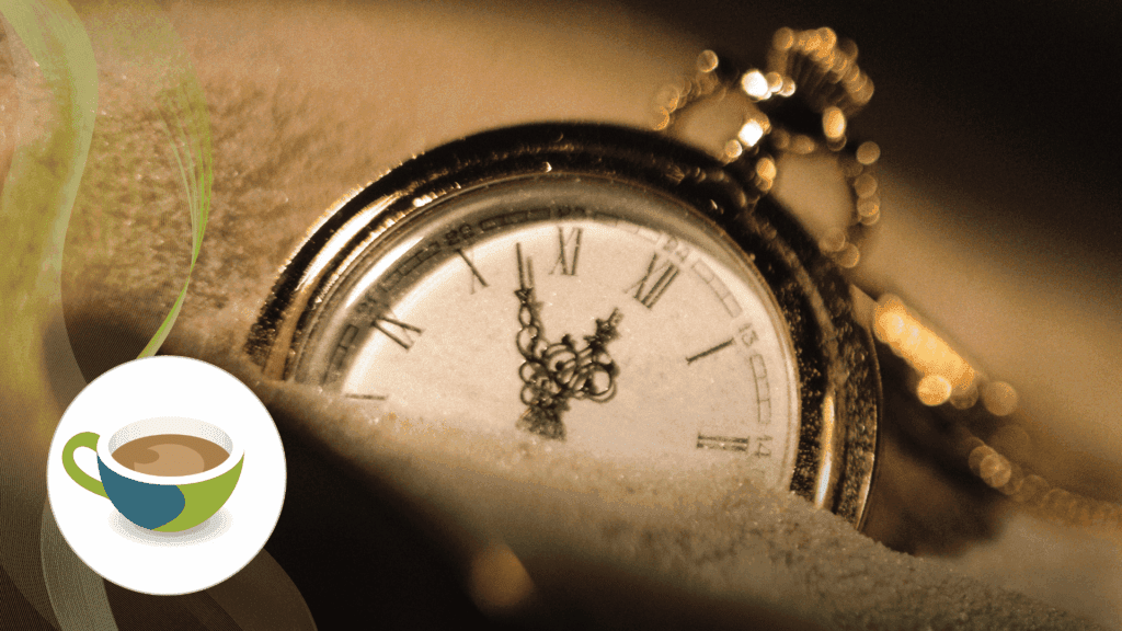 A close-up of a vintage pocket watch partially buried in sand, symbolising the passage of time.