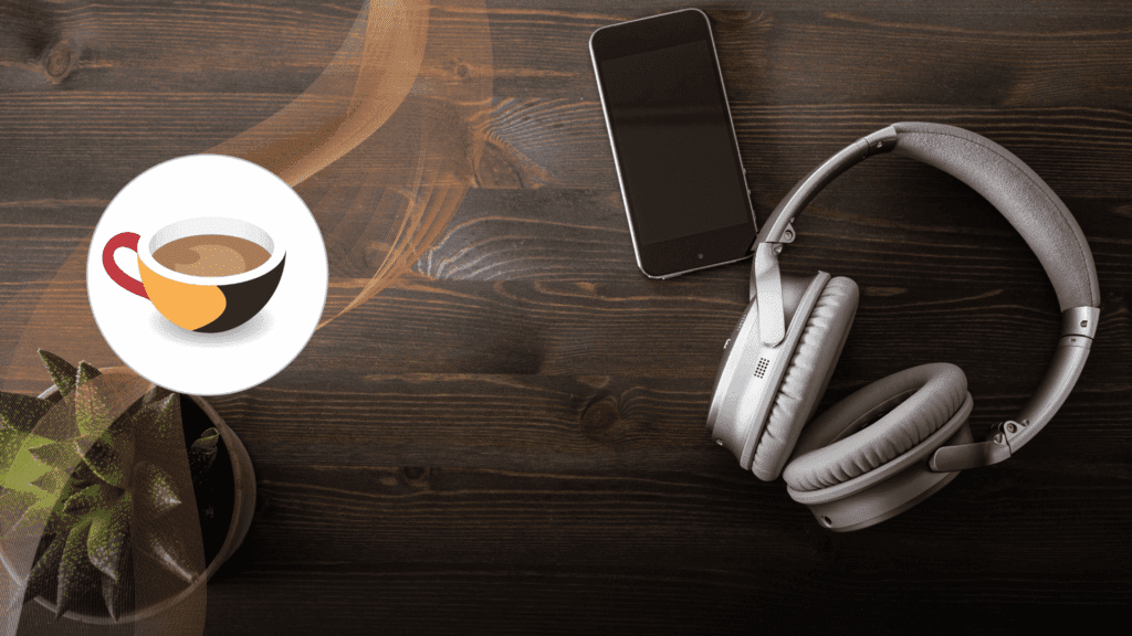 A phone and headphones resting on a dark table