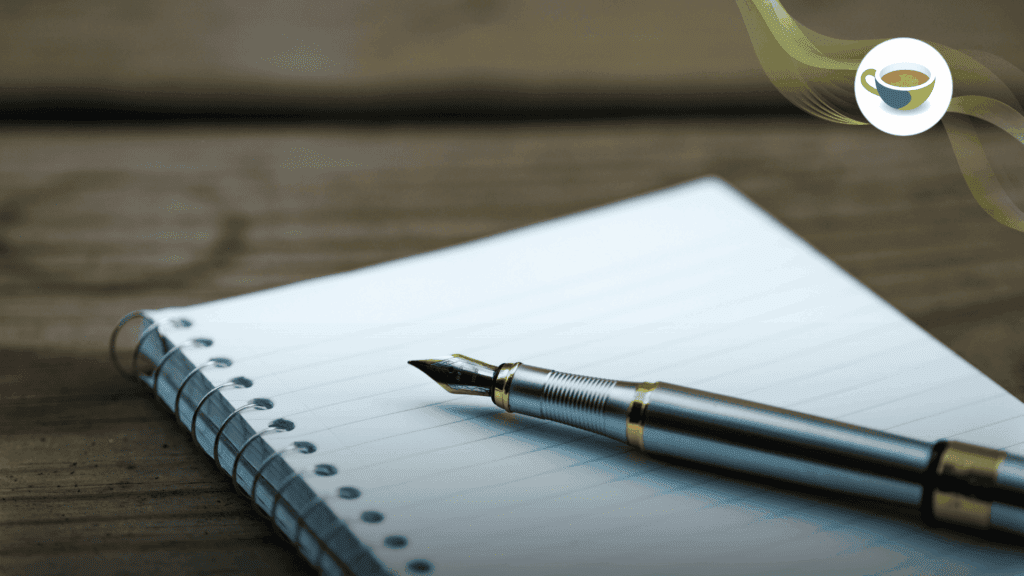 An ink pen sits on top of a blank notebook. 