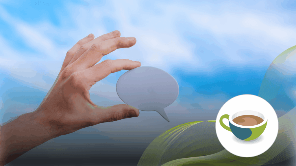 A hand holding a blank speech bubble cutout against a bright blue sky, symbolising conversation and communication.