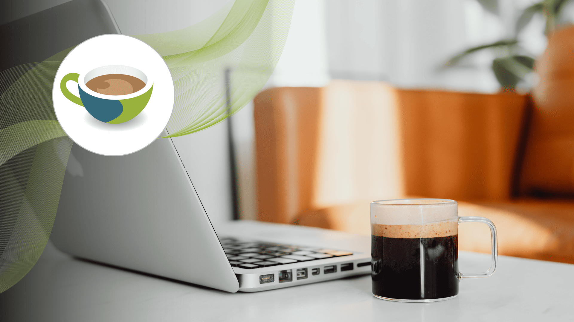 Laptop keyboard with a takeaway cup of frothy coffee on a small round table, alongside a wooden décor piece.