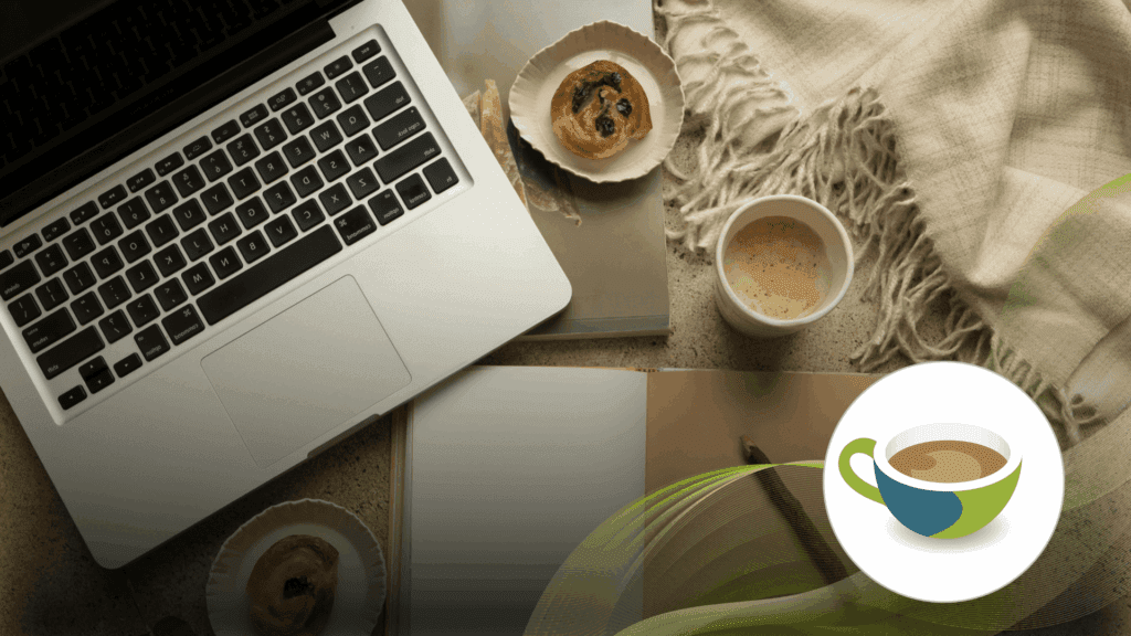 Cosy workspace with a laptop, notebook, coffee cup, and pastries on a textured surface, with a soft blanket.